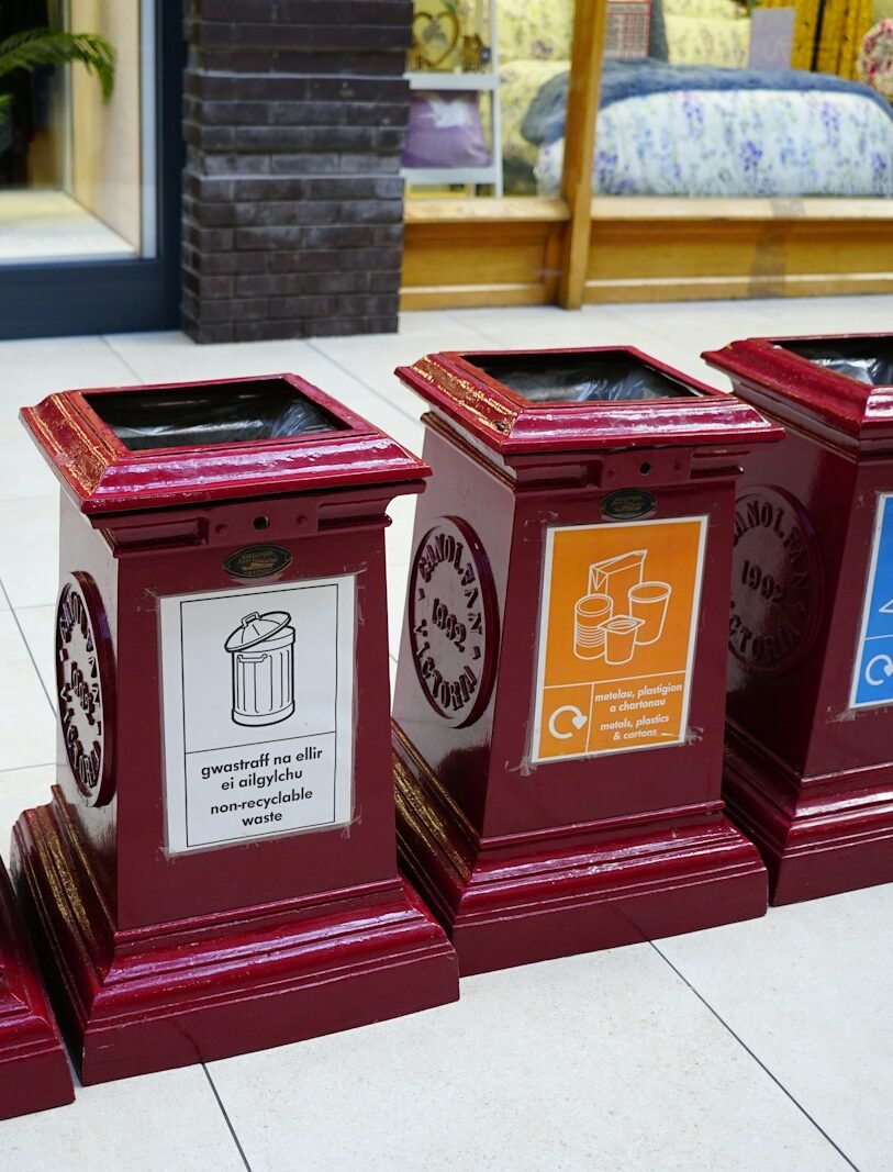 A row of red clocks sitting on top of a sidewalk
